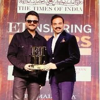 Dr. Amit Saxena holding a leadership award